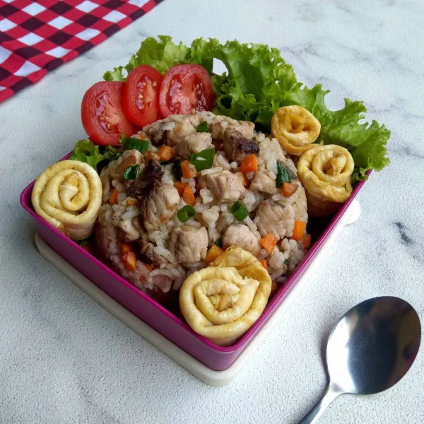 Siapkan nasi goreng tuna ceria dengan bahan pelengkap ke dalam kotak bekal.