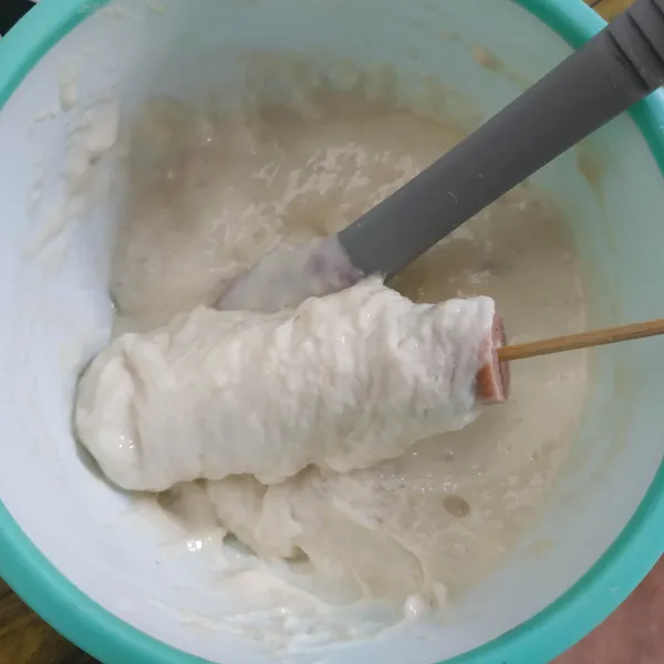 Celupkan sosis tusuk ke dalam adonan tepung.