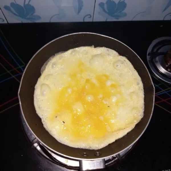 Dadar telur yang sudah dikocok ke dalam teplon.