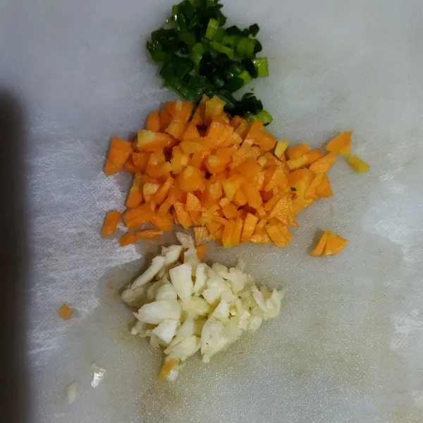 Potong dadu kecil wortel, iris tipis daun bawang, geprek lalu cincang bawang putih.