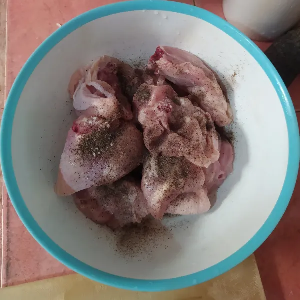 Marinasi ayam dengan lada hitam bubuk dan garam selama 30 menit.