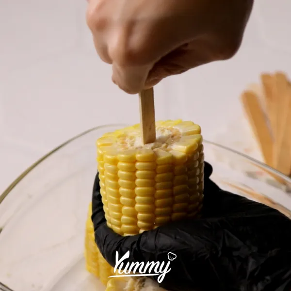 Siapkan jagung yang telah dipotong-potong, tusukkan dengan stik eskrim.