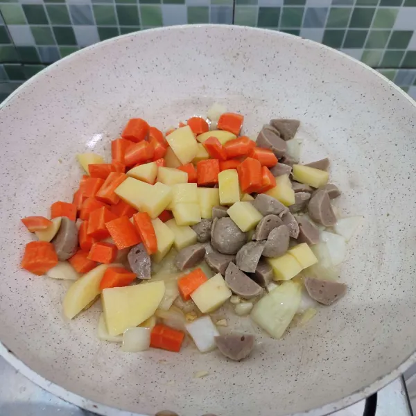 Kemudian masukkan bakso, wortel serta kentang, aduk rata. Tumis hingga sedikit layu.
