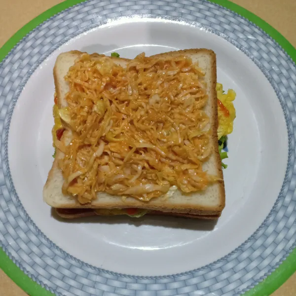 Tumpuk dengan roti tawar lagi beri salad kubis, ratakan.