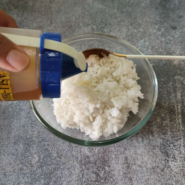 Pindahkan nasi ke wadah, campurkan dengan garam, dan minyak wijen, aduk rata.