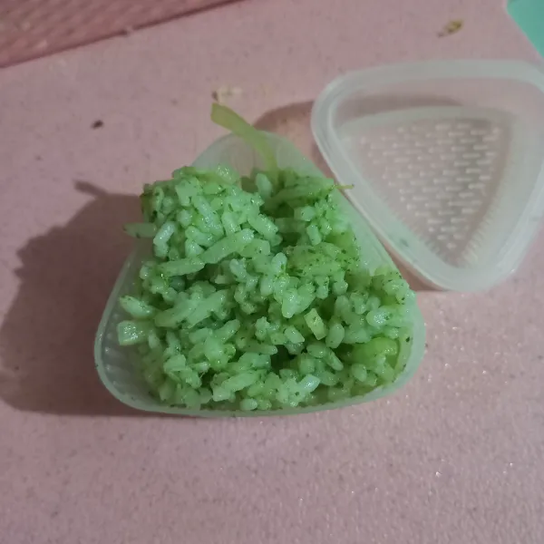 Cetak nasi pada cetakan onigiri, atau bisa juga dibentuk menggunakan tangan. Setelah itu bungkus pinggir dan bagian tengah dengan lembaran nori. Buat beberapa buah tergantung porsi makan anak.