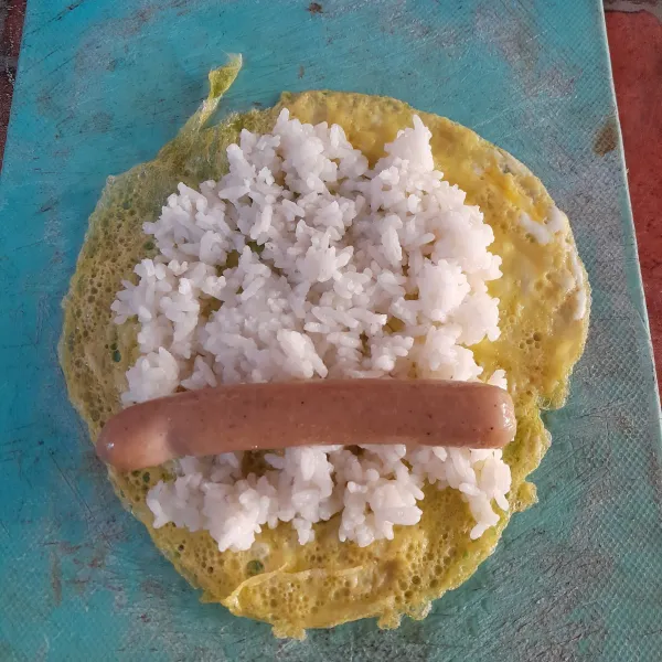 Goreng sosis sebentar, susun nasi dan sosis di atas dadaran telur, lalu gulung dengan rapat.