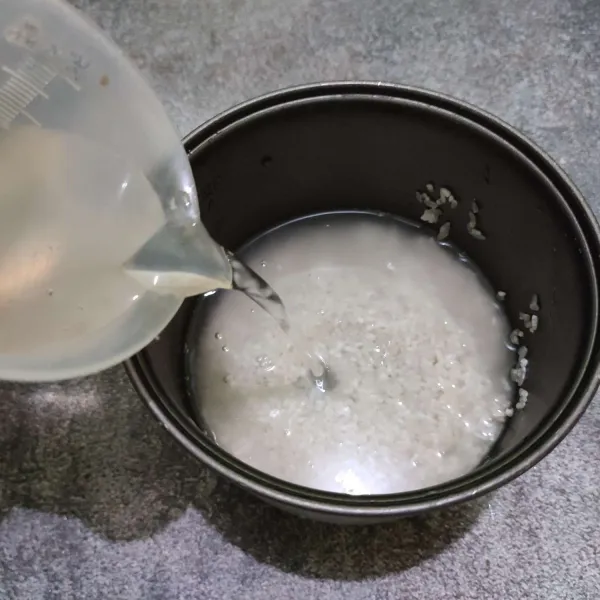 Cuci bersih beras, lalu beri air sesuai takaran memasak nasi.