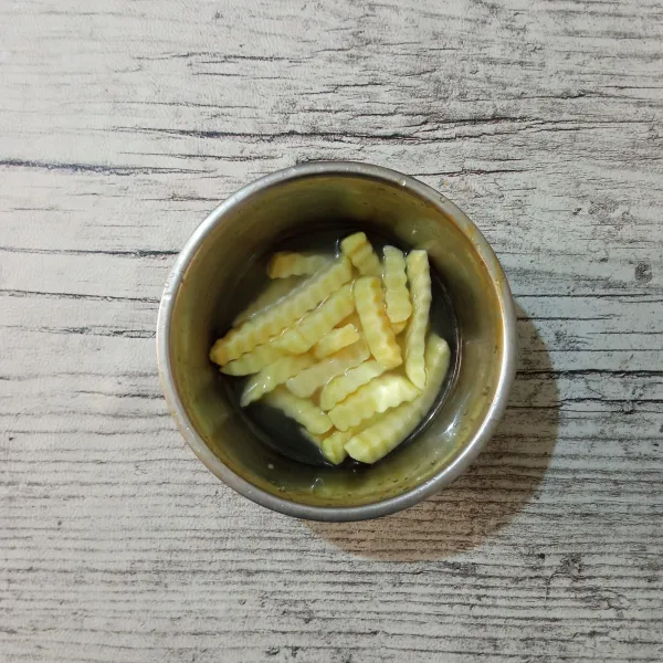 Masukkan potongan kentang ke dalam campuran air, rendam selama 15 menit.