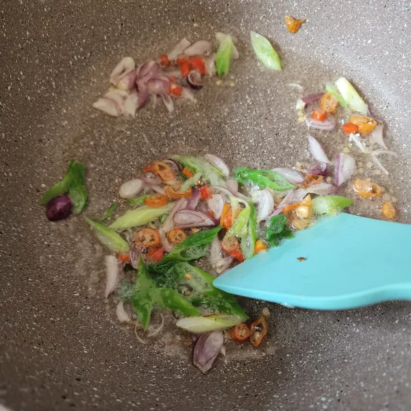 Panaskan wajan, tumis daun bawang, bawang merah dan cabai.