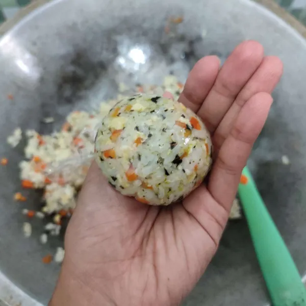 Ambil sedikit nasi, bulat-bulatkan dengan bantuan cling wrap.