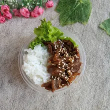 Tata dalam wadah, selada, nasi, beef teriyaki dan taburi wijen sangrai.