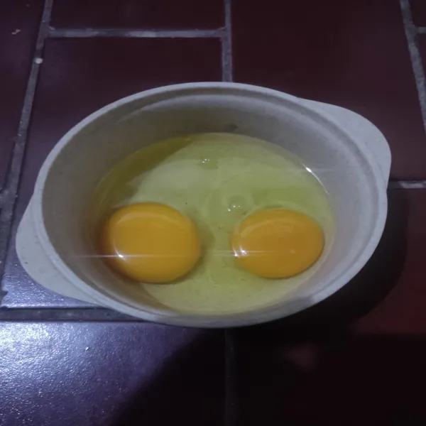 Pecahkan 2 butir telur lalu tambahkan kaldu bubuk dan lada bubuk.