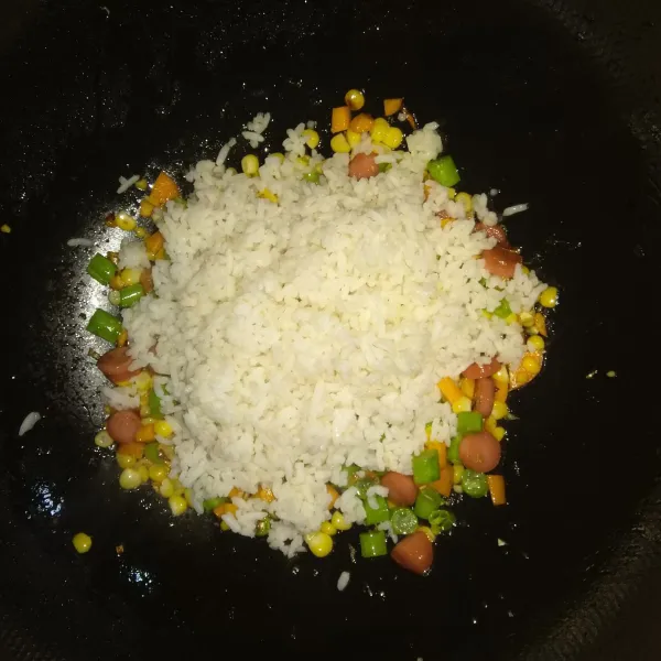 Masukkan nasi, aduk sampai rata dengan bahan lainnya.