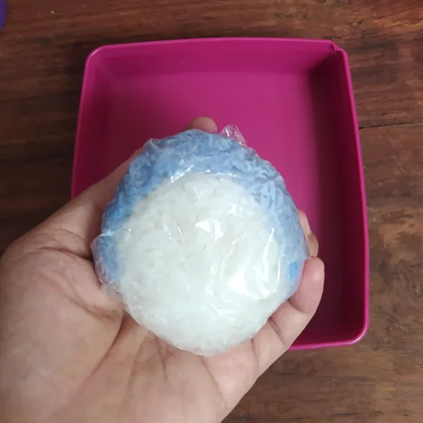 Beri nasi bunga telang di sekeliling nasi putih, padatkan lagi sehingga menyerupai kepala doraemon.