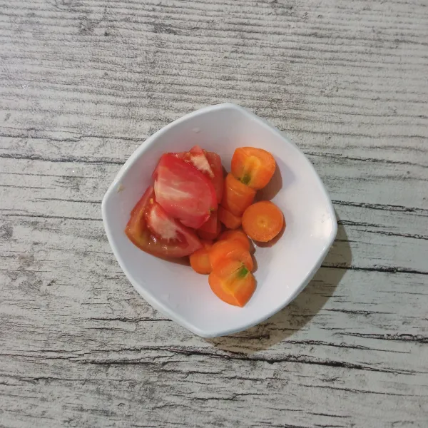 Cuci bersih tomat dan wortel, lalu potong-potong.