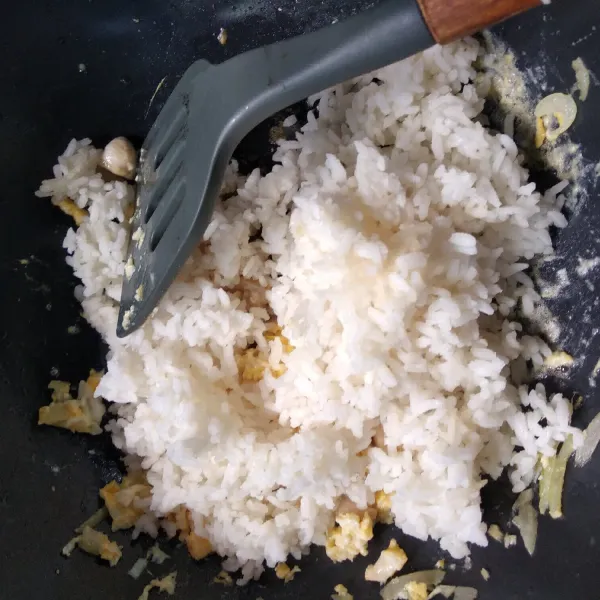 Masukkan nasi, garam, kecap, aduk rata.