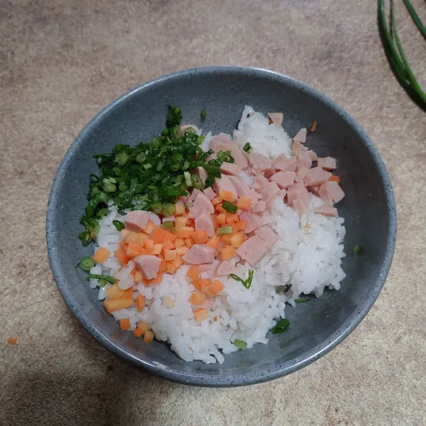 Siapkan nasi di mangkok, masukan wortel,sosis,daun kucai dan seledri iris. Aduk rata.
