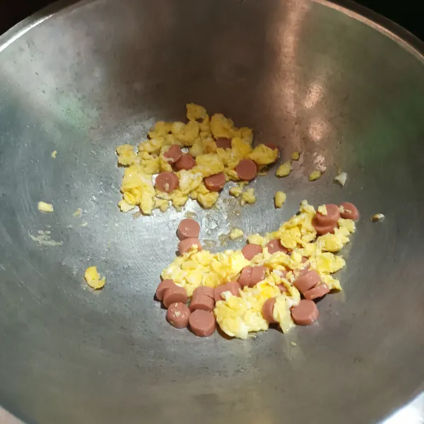 Panaskan minyak, lalu goreng telur acak-acak dan masukan sosis. Aduk rata.