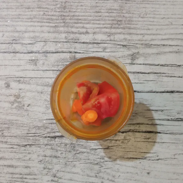 Masukkan potongan tomat dan wortel ke dalam blender.