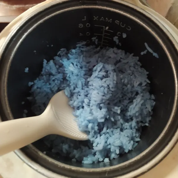 Rebus air dan bunga telang sampai warnanya berubah biru. Cuci beras, lalu masukkan air bunga telang sebanyak 225 ml. Masak di magic com seperti biasa. Setelah matang, aduk rata.