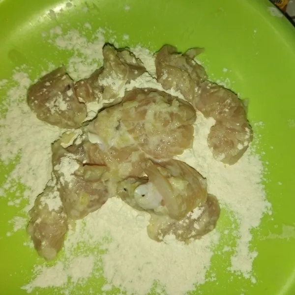 Panaskan minyak goreng, siapkan tepung bumbu serba guna, lalu masukkan daging ayam ke dalam tepung bumbu.