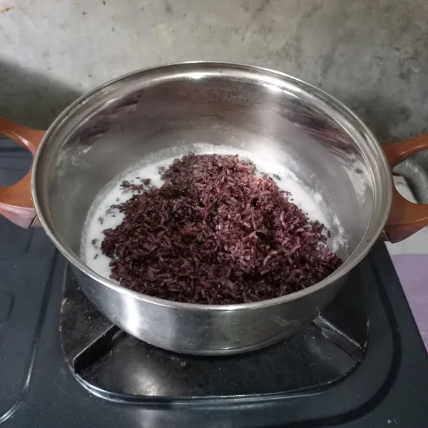 Masukkan ketan kukus dan aduk sampai air santan menyusut. Matikan kompor dan diamkan selama 5 menit supaya santan meresap.