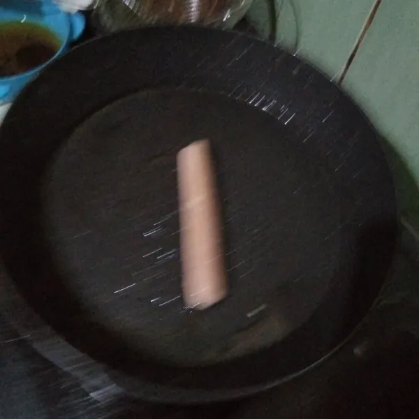 Siapkan wajan panas, tambah sedikit minyak. Lalu masukkan sosis dan goreng sebentar.