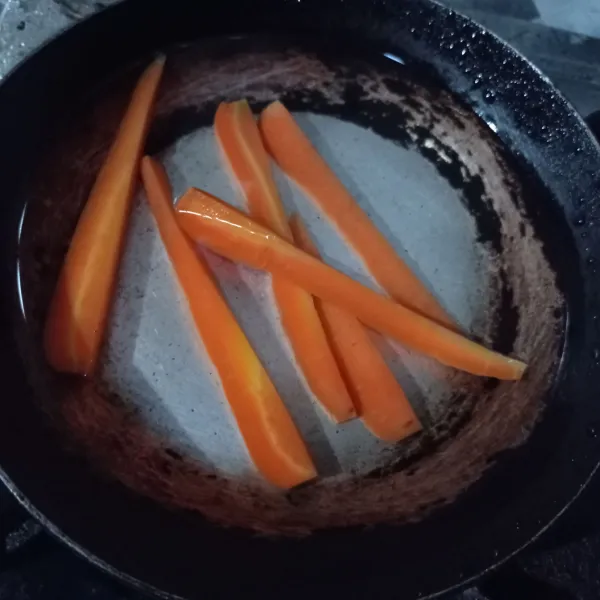 Belah wortel jadi 2 lalu potong memanjang lagi jadi 6 bagian, rebus wortel sampai matang, tiriskan.