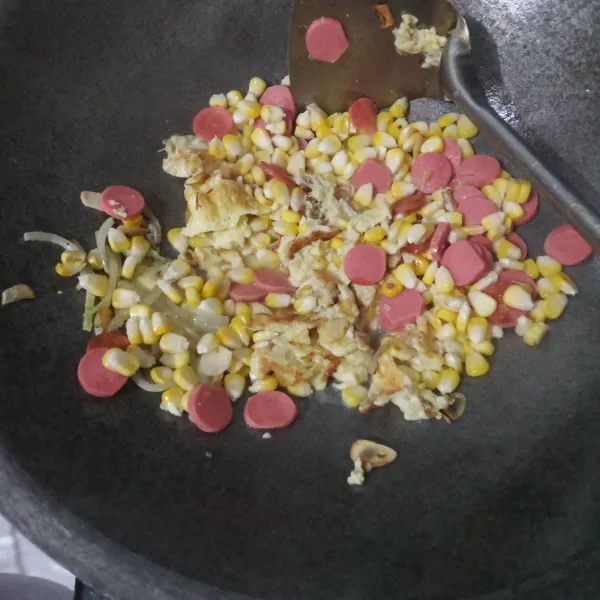 Masukkan sosis, jagung manis dan air. Aduk rata. Masak hingga jagung setengah matang.