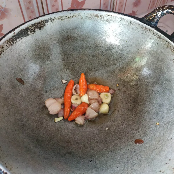 Goreng bawang putih, bawang merah dan cabai hingga layu.
