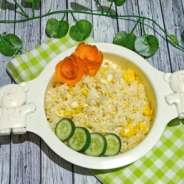 Sajikan egg butter rice, lalu taruh di pinggir irisan mentimun dan wortel bunga.