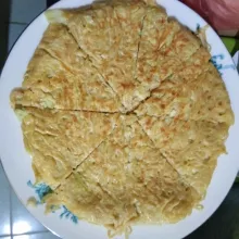 Pindahkan martabak mie pada piring. Belah seperti potongan pizza. Kemudian sajikan bersama nasi plus bawang tabur.
