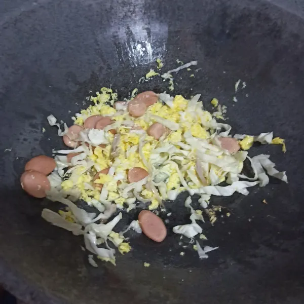 Tumis bawang putih cincang hingga harum. Masukkan telur, orak-arik hingga matang. Masukkan sosis dan kol.
