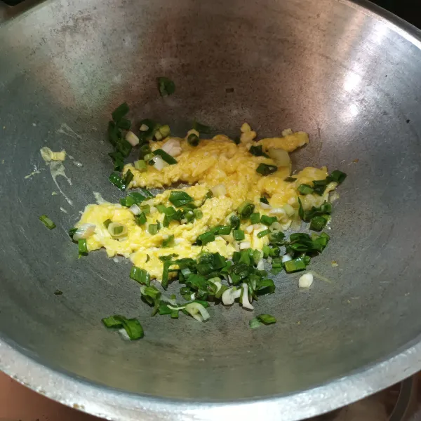 Lalu panaskan margarin. Masukkan telur masak orak-arik dengan daun bawang.