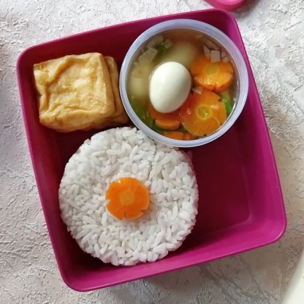 Tata nasi, tahu goreng dan sayur sup dalam kotak bekal. Sayur di wadah terpisah ya, tutup dengan rapat.