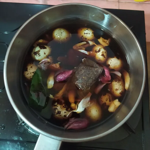 Masukkan ke dalam panci. Beri daun salam, teh celup, gula merah, garam, kaldu bubuk, dan kecap manis.
Geprek bawang putih dan bawang merah. (Tidak perlu dikupas/ utuh).
Tuang air, lalu rebus dengan api kecil. Aduk supaya gulanya larut.