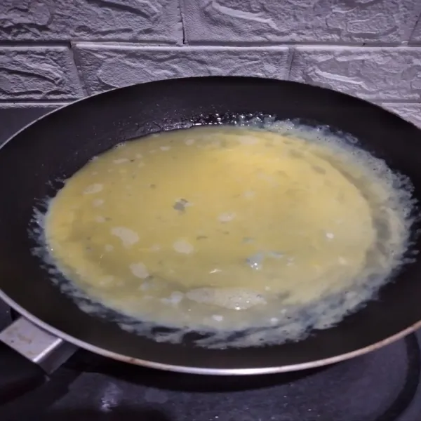 Kocok telur, tambahkan air, kaldu penyedap, kocok lalu tuang di teflon.