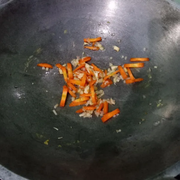 Panaskan minyak, tumis bawang merah dan bawang putih hingga harum lalu masukkan wortel, aduk rata.