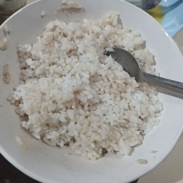 Campur nasi dengan kecap asin dan minyak wijen, aduk sampai tercampur rata.