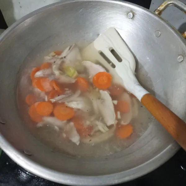 Tuang air, biarkan mendidih lalu masukkan wortel dan ayam. Masak hingga wortel hampir empuk.