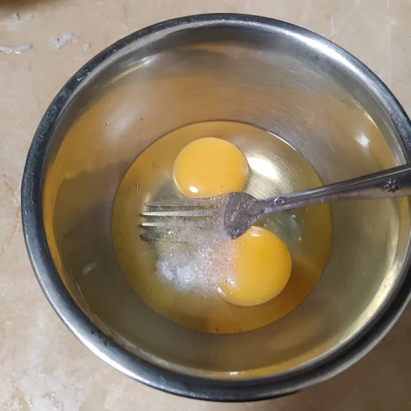 Pecahkan 2 butir telur, bumbui dengan garam, lada dan kaldu bubuk. Kocok rata.