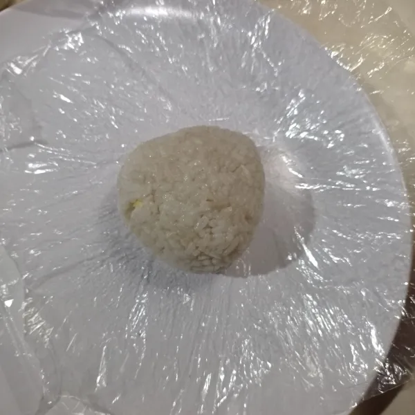Lalu kepal-kepal nasi sampai padat bentuk segitiga, lakukan sampai selesai.