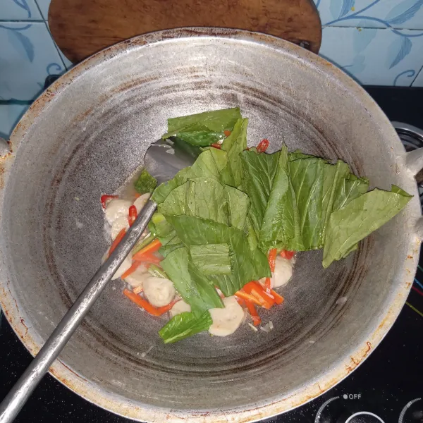 Masukkan daun pakcoy dan aduk-aduk hingga pakcoy layu. Jika pakcoy sudah layu maka sayur sudah matang dan siap disajikan.