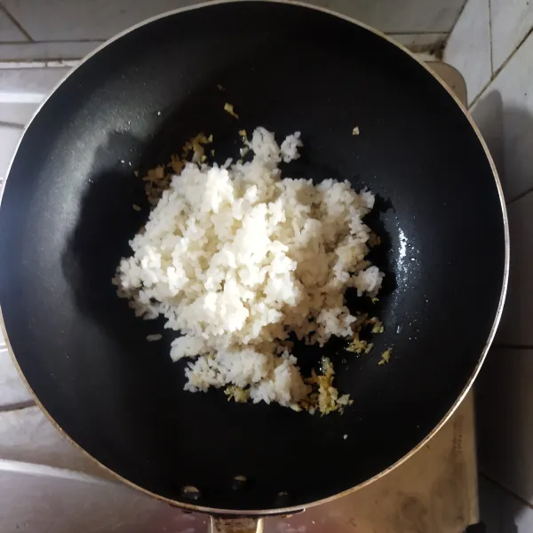 Tambahkan nasi putih, penyedap jamur dan garam lalu aduk hingga tercampur rata.