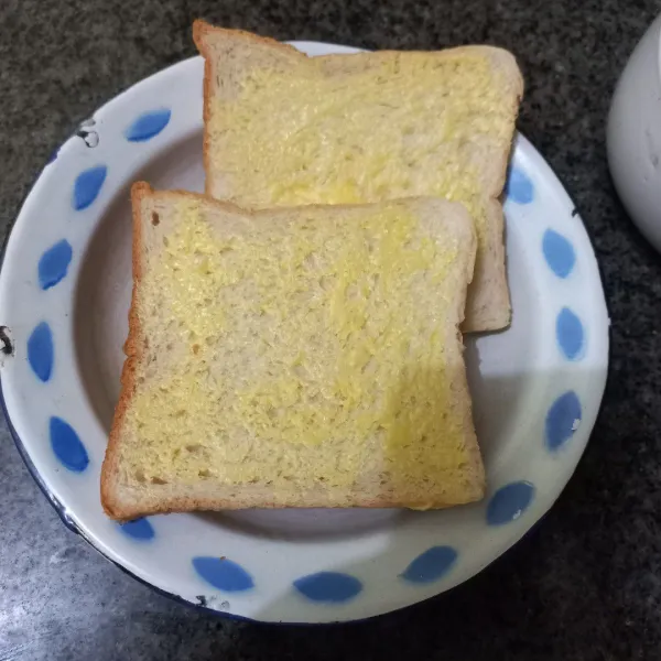 Siapkan roti tawar, olesi dengan margarin salah satu bagian masing-masing roti