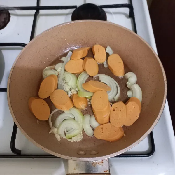 Panaskan minyak goreng, tumis bawang putih cincang dan irisan bawang bombay hingga harum