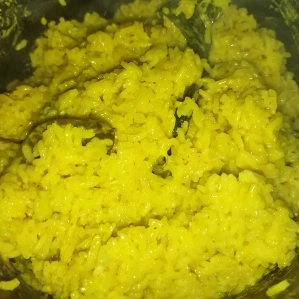Kemudian aduk-aduk nasi kuning, lalu sajikan.