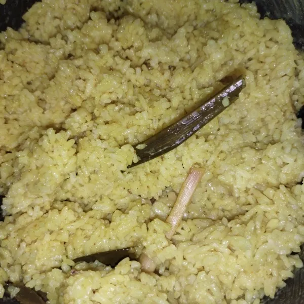 Siapkan bahan nasi kuning, masukkan semua bahan nasi kuning ke dalam magic com, tekan tombol cook, jika sudah matang, tunggu beberapa saat, lalu aduk-aduk, nasi kuning siap dibentuk.