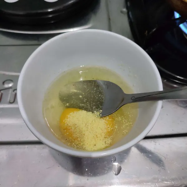 Kocok lepas telur dengan kaldu bubuk dan merica.